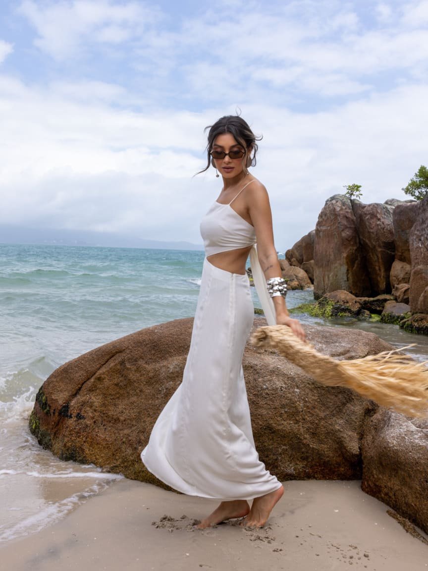 vestido-resort-recorte-viscose-linho-praia 01 Mulher usando vestido longo branco de viscose com linho e recorte na cintura na praia